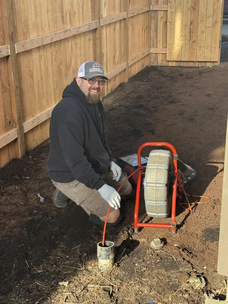 InspecTek West inspector running a sewer camera into a cleanout