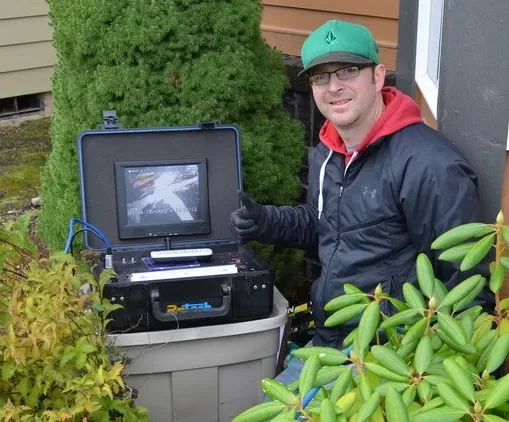 InspecTek West inspector viewing the sewer line on a monitor during a scope